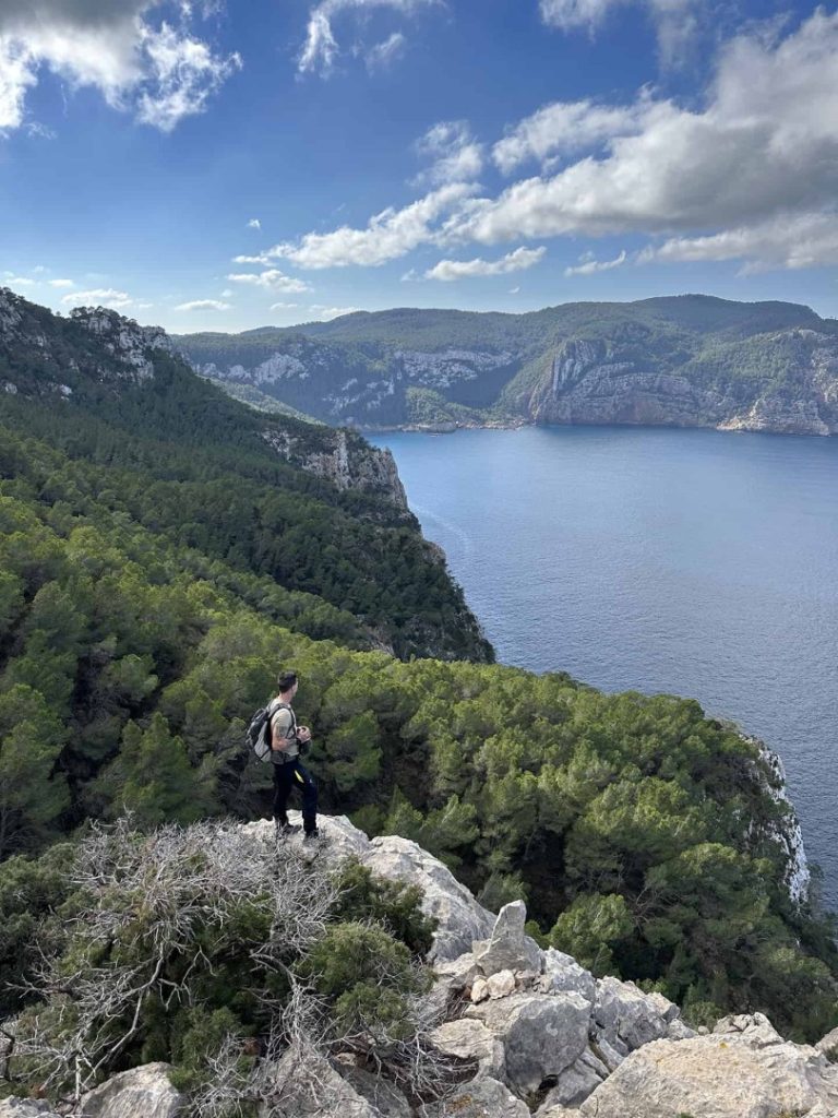 Hiker enjoying the view on Ibiza coastline during Evergreen Hike Station scenic coastal hiking adventure