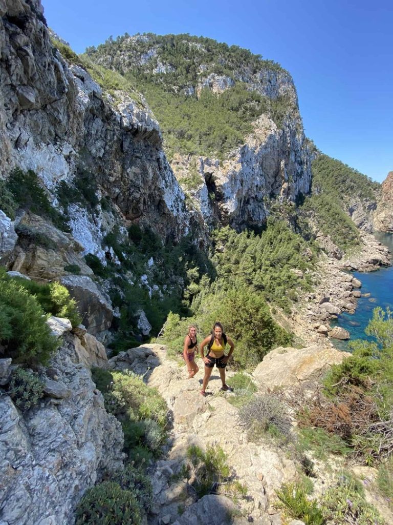 Hikers climbing scenic coastal trail with cliffs and sea views during Sardina Hike Station adventure hike in Ibiza