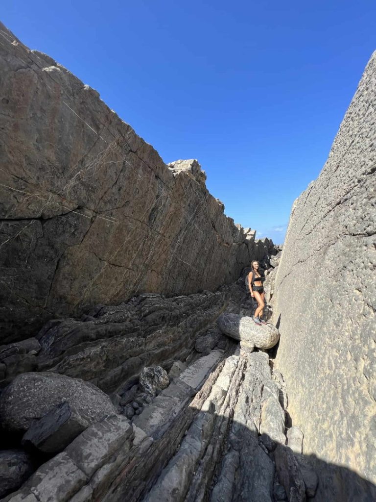 Hiker walking through dramatic limestone rock canyon on Ibiza’s adventurous Stone Hike Station coastal trail