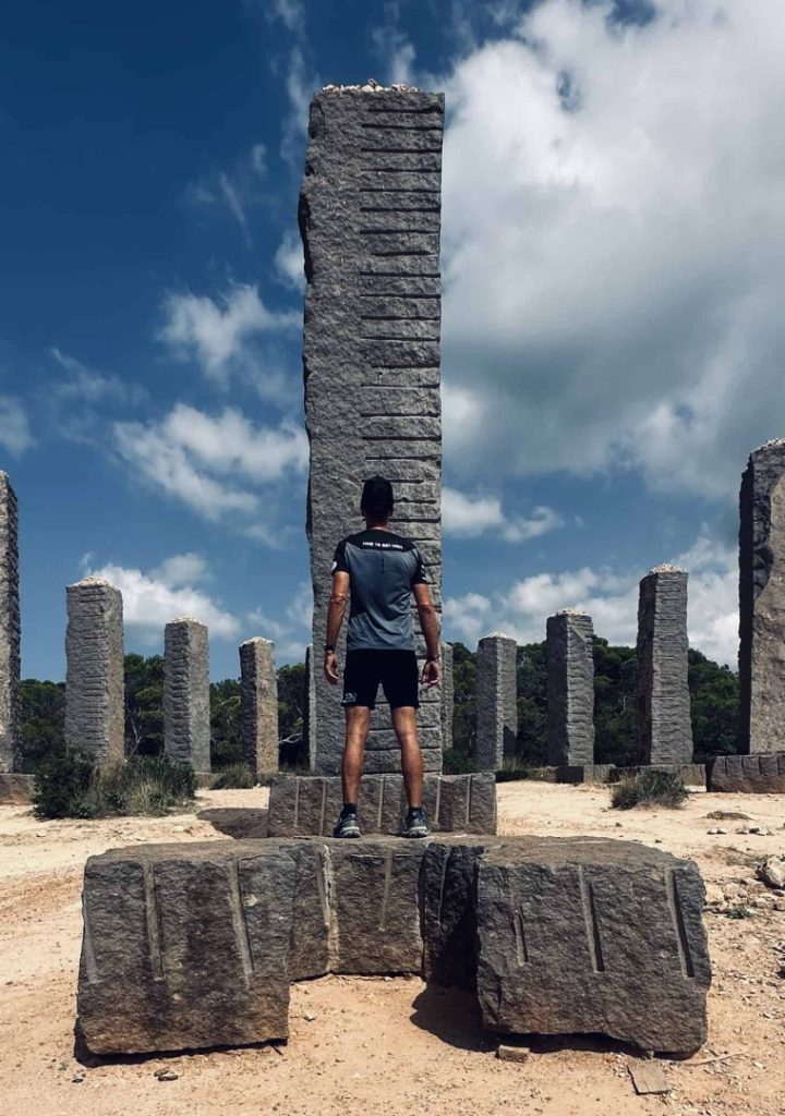 Hiker exploring ancient stone pillars during tailor-made guided hiking adventure with Ibiza Hike Station