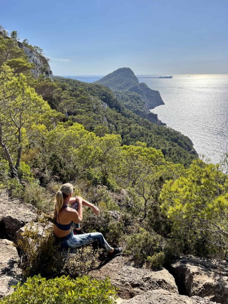Hiker enjoying panoramic views of Ibiza’s rugged coastline and Mediterranean cliffs on the scenic Lagoon Hike Station trail