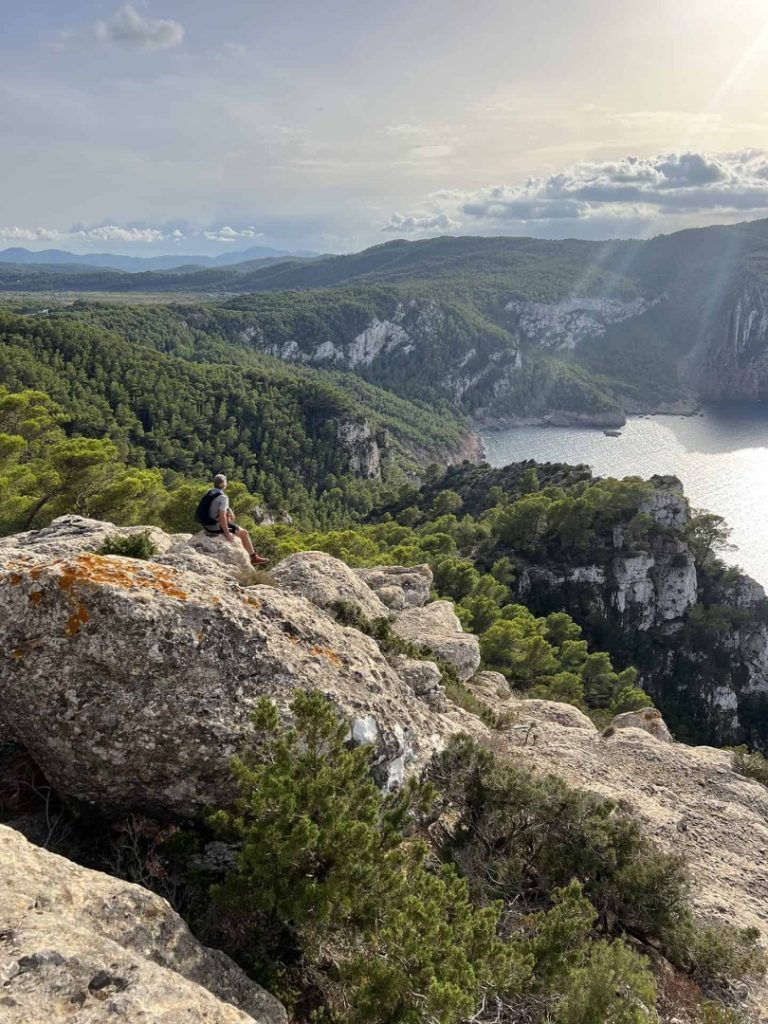 Hiker enjoying panoramic cliffs and Mediterranean coastline views on the Quelona Hike Station scenic hiking route in Ibiza
